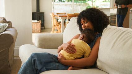 Mother Embracing Her Baby While Relaxing at Home in the Afternoon