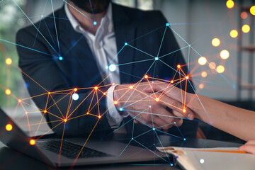 Business handshake with digital network overlay in office setting.