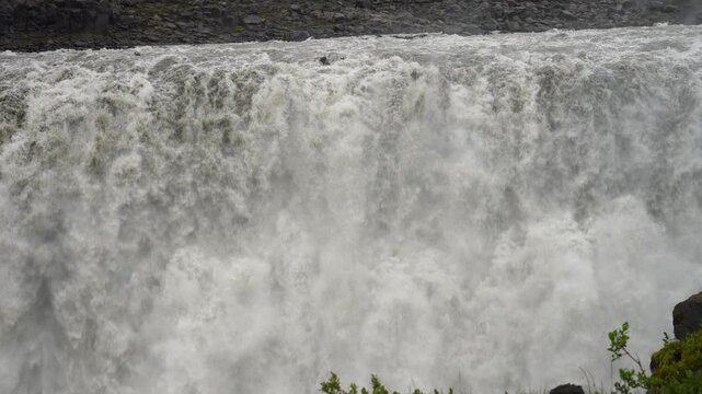 Dettifoss waterfall in Iceland, captured in slow motion, reveals the powerful and dramatic flow of water cascading into a rugged canyon, creating a mesmerizing and awe-inspiring natural spectacle.