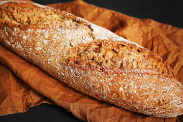 Fresh bread on a brown napkin on a dark background