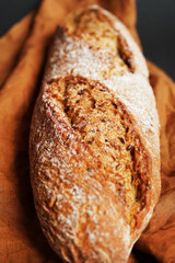 Fresh bread on a brown napkin on a dark background