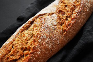 Fresh bread on a black napkin on a dark background