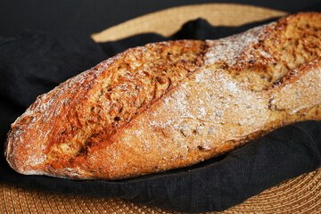 Fresh bread on a black napkin on a dark background
