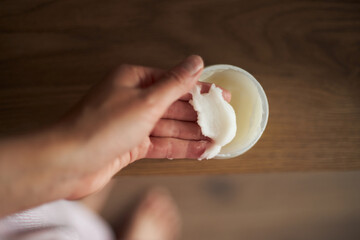 Hands taking natural moisturizing cream 