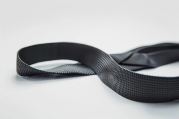 A close-up of a yoga strap being used for a seated forward fold