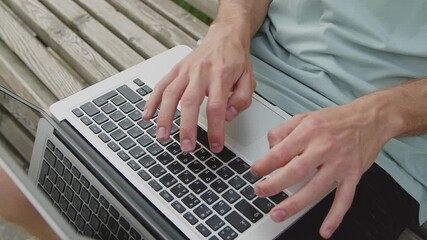Close-up of a man's hands typing on a laptop keyboard - Powered by Adobe