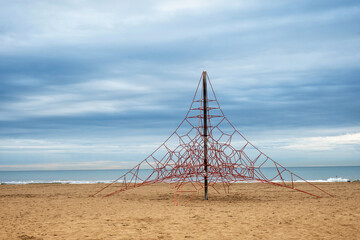 Children playground rope climbing pyramid on a beach