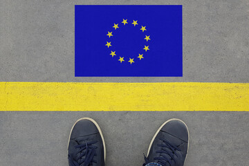Word Start on an asphalt road with the EU flag  and legs in shoes. Immigration and Travel in...