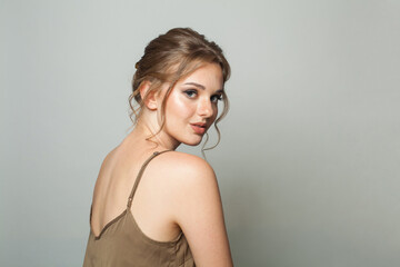 Fototapeta premium Attractive female model with healthy skin, natural makeup and perfect updo hairstyle, fashion beauty studio portrait