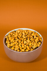 Corcflakes or Marning or marneng is traditional snack from indonesia. Made from corn kernels that fried. Fried corn in bowl with isolated background