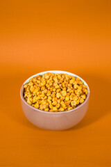 Corcflakes or Marning or marneng is traditional snack from indonesia. Made from corn kernels that fried. Fried corn in bowl with isolated background