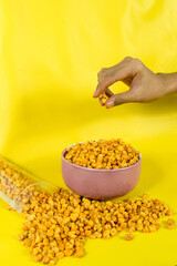 Corcflakes or Marning or marneng is traditional snack from indonesia. Made from corn kernels that fried. Fried corn in bowl with isolated background