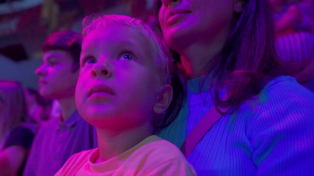 Spectators in a circus. Happy family with small child watching a circus performance. Little boy at circus. Simferopol, Crimea