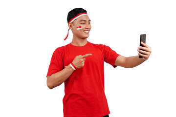 An Indonesian man celebrating Indonesia's independence day on 17 August while holding smartphone...