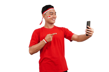 An Indonesian man celebrating Indonesia's independence day on 17 August while holding smartphone with blank screen and pointing isolated transparent
