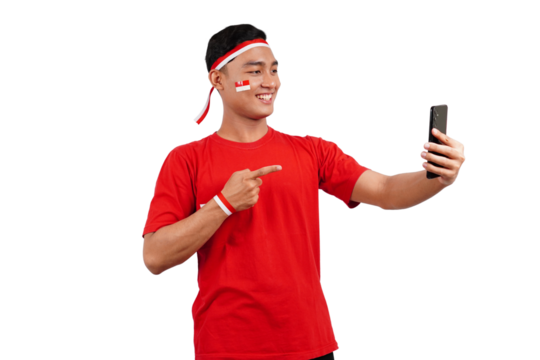 An Indonesian man celebrating Indonesia's independence day on 17 August while holding smartphone with blank screen and pointing isolated transparent