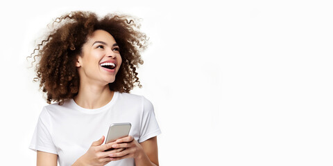 Mujer feliz sujetando un smartphone. Mujer afro riendo con camiseta blanca. Chica castaña riéndose sobre fondo blanco. Mujer aislada con celular de última generación.