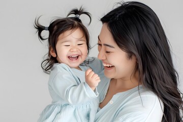 Smiling Asian Mother Holding her Daughter