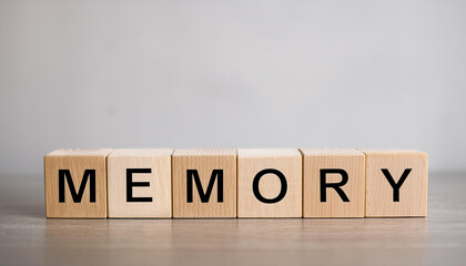 Wooden cubes with word MEMORY on table against light gray background.