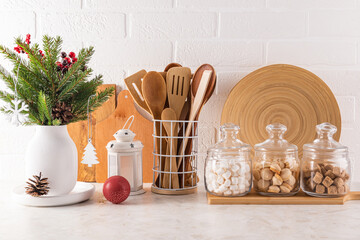 Spruce bouquet in a white vase, Christmas decorations on the countertop kitchen eco-friendly utensils. glass jars with bulk products for the holiday.