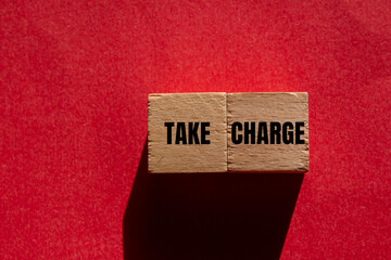 Take charge message wooden cubes on red background. Conceptual take charge symbol. Copy space.