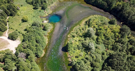 karst blue lake in the forest and SUP boards