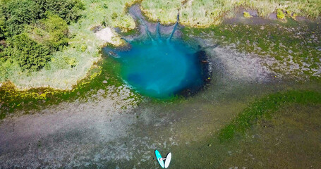 karst blue lake in the forest and SUP boards
