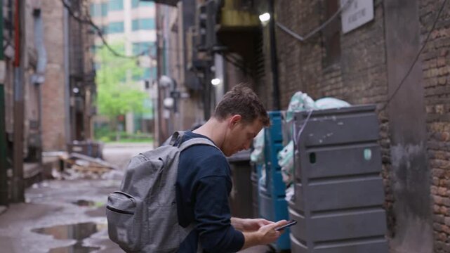 Guy lost in a big city. tourist walking around New York navigating his way with his smartphone. looking lost, scared or sad. Manhattan. bad side of town. sight seeing. the slums of NY.