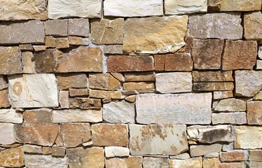 Rough and dirty exterior wall with stones of different shapes and colors and concrete. Background and texture.