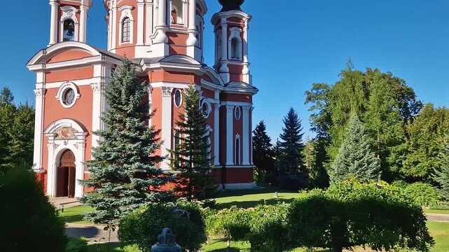 Curchi Monastery outdoor view. Christian Orthodox style church traditional for eastern Europe culture located in Orhei, Moldova. Beautiful garden with trees around the basilica and the big bell
