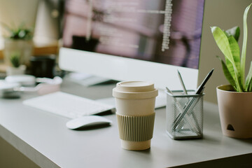 No people shot of reusable coffee cup on table at workplace in modern IT company office