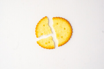 Single cracked broken or divided yellow biscuit on isolated white background
