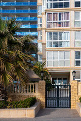 Gate entrance to a modern multi-store apartment building, concept luxury living, property sale or rent at holiday destination