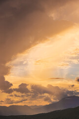 Dramatic Sunset with Cloudy Sky over Mountains