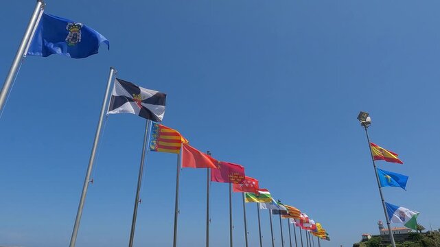 Banderas ondeando al viento de las comunidades aut&oacute;nomas y territorios de Espa&ntilde;a en el puerto de Cudillero