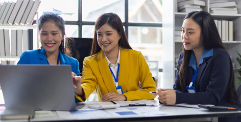 Three Asian businesswomen discuss presenting a new project idea. Analyze financial and investment market planning and statistics at the office using tablet pc and smiling.