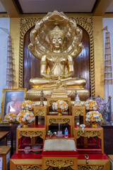 Phra Nakhon Si Ayutthaya District, Wat Tuek, Thailand, July 07, 2024, Serene Golden Buddha with Naga Hood.