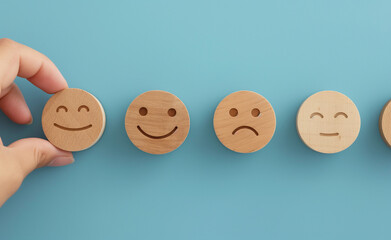 Hand picking a wooden face with different expressions.