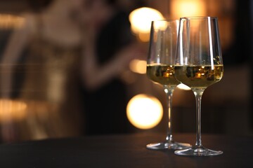 Tasty wine in glasses on black table indoors, selective focus