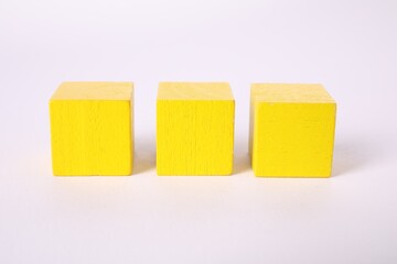 Many yellow wooden cubes isolated on white