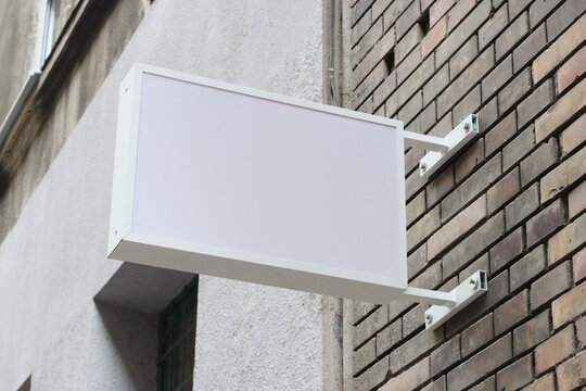 Street storefront shop, cafe, restaurant mounted signboard mock up design template. Blank white store sign design mockup.