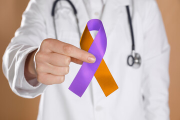 World Psoriasis Day. Doctor with orange and orchid ribbon as symbol of support on dark beige...