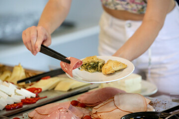Woman taking food from a buffet line