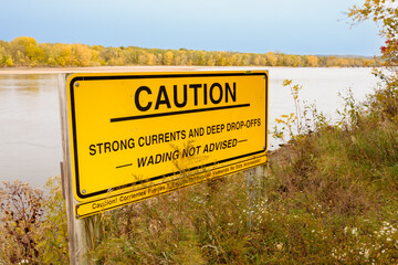 Caution sign advising no wading along the shoreine of the Wisconsin River at Spring Green, accented...