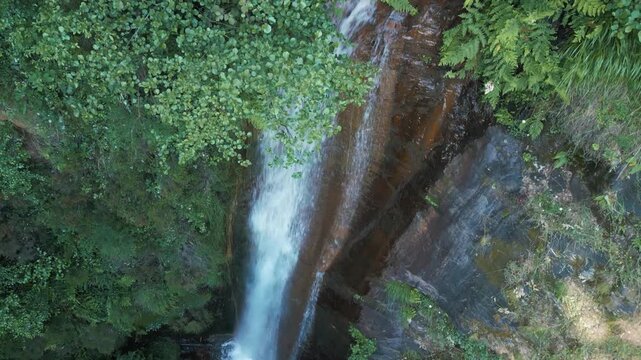 Drone of Rexio Waterfall surrounded by vegetation in a forest in Folgoso do Courel, Lugo, Spain