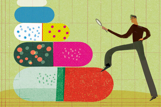 Man looking at pills forming staircase through magnifying glass