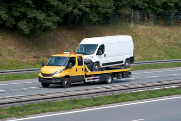 Road Assistance Tow-Truck With Out-Of-Order Commercial Cargo Bus On Flatbed