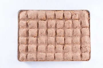 Top view of milky cold baklava with pistachio on a tray isolated on white background.