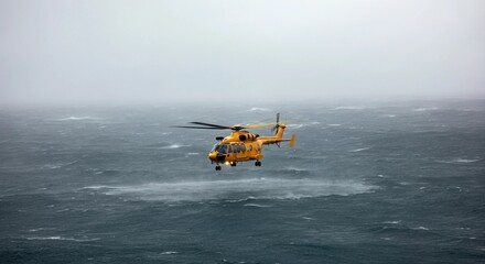 Fototapeta premium A rescue helicopter hovering above a turbulent ocean, battling heavy rain and powerful gusts as it searches for a stranded vessel. 