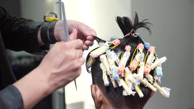 パーマロッドを巻く美容師